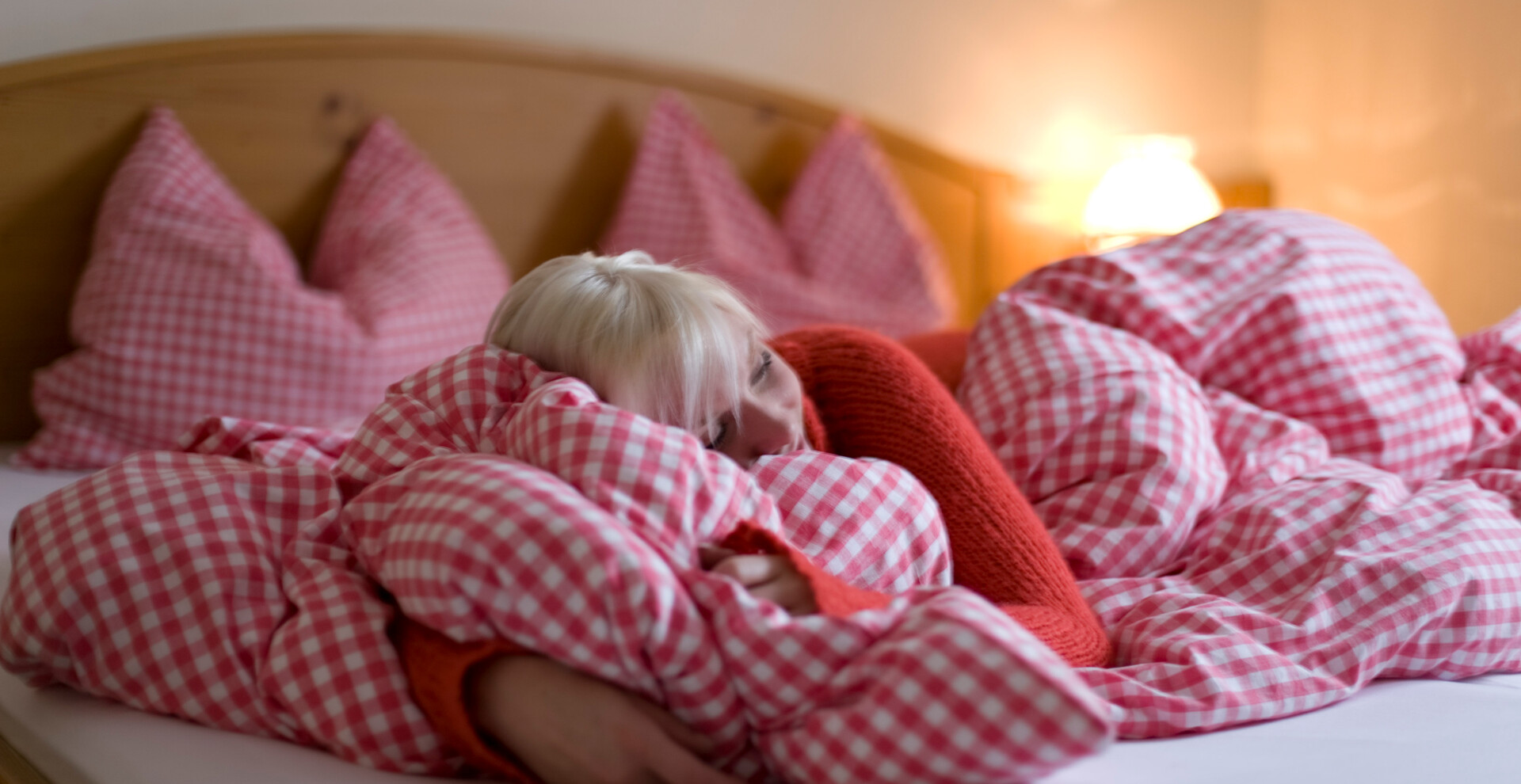 schlafen, karierte Bettwäsche, Frau liegt im Bett | © ikarus.cc