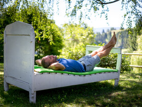 Bett im Garten, Mann beobachtet Bäume | © Steiermark Tourismus_Tom Lamm