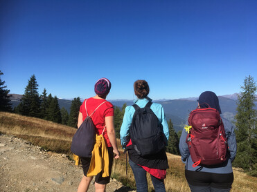 3 Frauen mit dem Rücken beim Pilgern