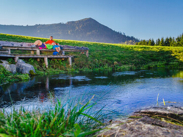 Paar beim Relaxen auf Bank, Ursprungsquelle | © TVB Naturpark Zirbitzkogel-Grebenzen | Mediadome